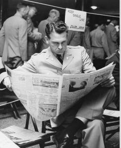 A man reading a newspaper inside the Pentagon while he waits to register for classes at UMUC.